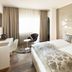 Hotel Uzwil in Uzwil: modern guest room with twin beds, desk, chair and large window with curtains
