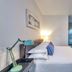 Oasis Hotel Fort Lauderdale guest room with bed, desk lamp and turquoise accents