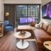 The Rally Hotel at McGregor Square in Denver: lounge with leather sofa, blue chair, and city-view window