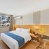 Aishangyijia Hotel Wuhu room with king bed, city view window, wall-mounted TV, and air conditioner