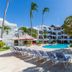 Sosua By The Sea in Sosúa with pool, sun loungers, palm trees and white hotel buildings