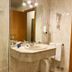 SHS Hotel Aeropuerto Madrid bathroom with sink, mirror, shower and towel rack