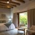 Visus Hotel Boutique & Spa guest room with king bed, exposed beams and garden view through sliding door in Fonda Central