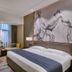 Henan Sky-Land Gdh Hotel in Zhengzhou guest room with king bed, desk, large window and city view