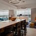 Hampton Inn New York-JFK in Queens, modern hotel lounge with bar seating and dining tables