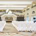 Waldorf Astoria Ras Al Khaimah grand ballroom set for a wedding ceremony with white chairs and chandeliers