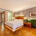 James Joyce Coffetel Hotel in Qinhuangdao guest room with king bed, wood floor, and bedside lamps