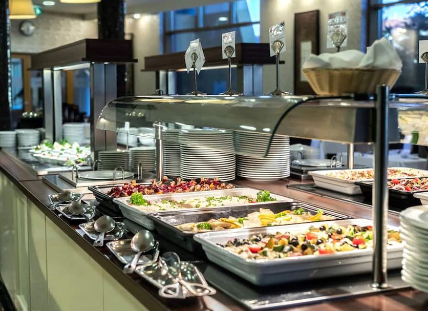 Colosseum Hotel in Mórahalom buffet station with trays of salads and hot dishes under a glass display