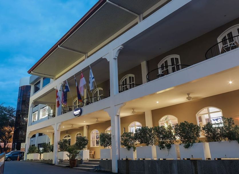 Kingsleys Hotel And Gastro Pub in Angeles City, illuminated exterior with balconies and flags