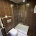Sor Hotel Eskisehir bathroom with shower, toilet, and brown tiled walls in Eskişehir