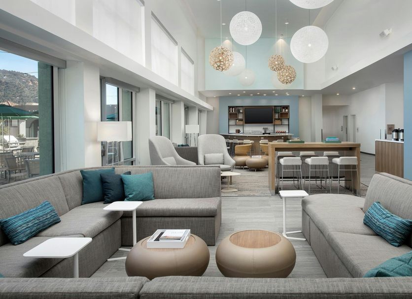Element Sedona lobby with gray sectional seating, pendant lights, bar seating and mountain views