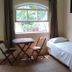 Hotel Vale Verde Penedo room with single bed, small table and chairs beside a window overlooking greenery.