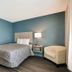WoodSpring Suites Morrisville - Raleigh Durham Airport guest room with bed, lamp and chair in Morrisville
