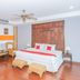 Evergreen boutique Hua Hin room with king bed, wood panel headboard, wicker chairs, and polished floors in Hua Hin