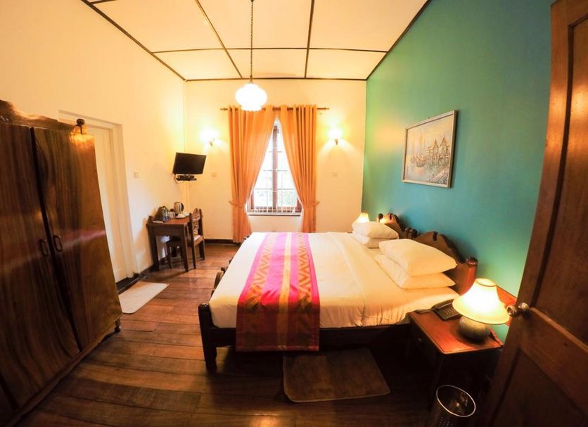 Hotel Glendower in Nuwara Eliya guest room with double bed, teal accent wall and window curtains