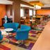 Fairfield Inn & Suites by Marriott South Bend Mishawaka lounge with blue chairs and colorful carpet in Mishawaka