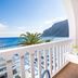 Balcony sea view at Hotel Sunshine in Kamari with table, chairs, and mountain backdrop
