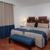 Monte Dos Apóstolos in Portalegre: twin beds, blue bench and bedside lamps in a simple guest room