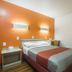 Motel 6 Lakewood, Co - Denver guest room with queen bed, orange accent wall, and wood-style flooring