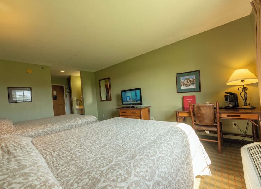 Santa's Lodge in Santa Claus guest room with two beds, desk, TV and lamps