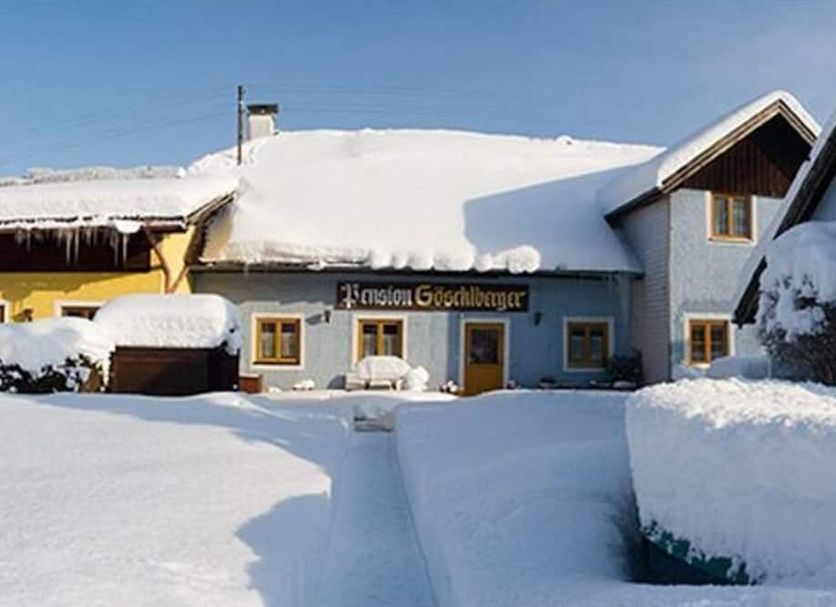 Pension Göschlberger in Mondsee covered in snow with a wintery facade and snowy courtyard