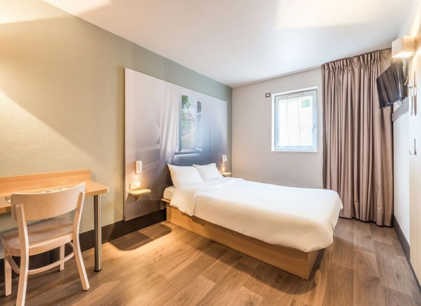 B&B HOTEL Strasbourg Sud Ostwald room with bed, desk, window and curtains in Ostwald