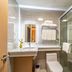 Shanghai Joyful Yard Hotel bathroom with glass shower, sink, toilet, and towel rack in Shanghai