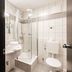 Mercure Hotel Pforzheim bathroom with shower, sink and toilet in white tile