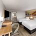 Days Inn by Wyndham Harrisonburg guest room with two beds, wall-mounted TV, desk, and chair