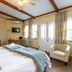 Evergreen Manor and Spa in Stellenbosch guest room with king bed, armchair, and balcony doors