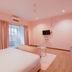 Palette Pink Cabana George Town room with pink walls, king bed, TV, balcony door and wood floor