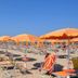 Ristorante Hotel Lucia in Giulianova with orange beach umbrellas and sun loungers on sandy shore