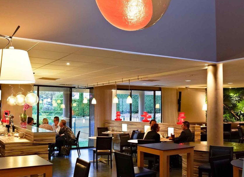 ibis Chalon-sur-Saône Europe lobby with hanging pendant lights and seating area in Chalon-sur-Saône