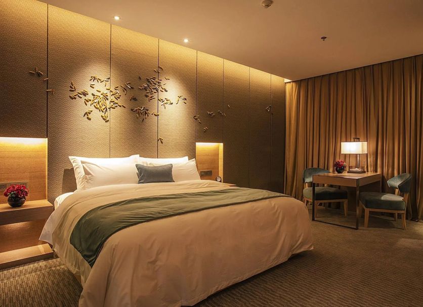 Chongqing Sunshine Continental Grand Hotel guest room with king bed, desk, and warm ambient lighting in Chongqing