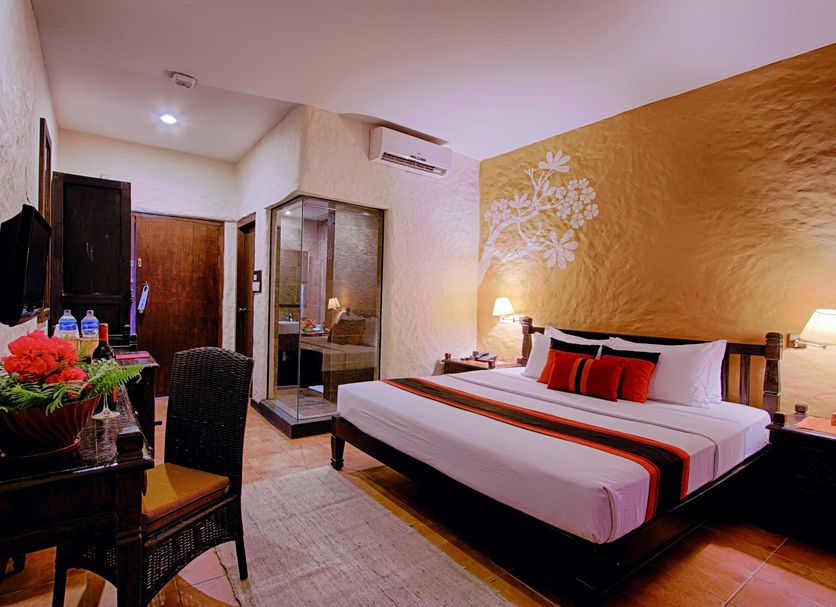 Temple Tree Resort & Spa, Pokhara room with king bed, desk, and mirrored wardrobe