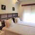 Hotel Peninsular, Caldelas: twin beds with padded headboard, wall art, air conditioner and sheer-curtained window