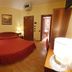 Hotel Diana in San Zeno di Montagna guest room with red bed, mirror wall and bathroom doorway