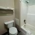 Hotel Piney Woods Huntsville bathroom with toilet, tub-shower combo, and towel shelf