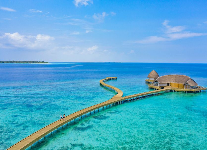 Emerald Faarufushi Resort & Spa in Ifuru with a long overwater walkway to a thatched lagoon pavilion