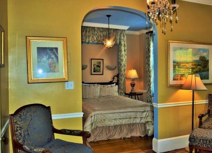 Inn on Bellevue in Newport guest room with arched doorway to a bed, chandelier, and warm decor