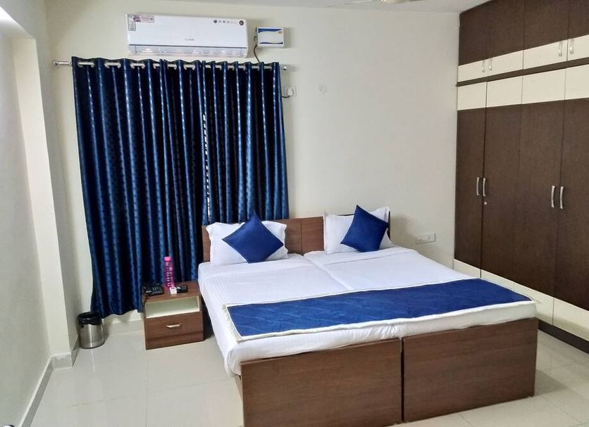 Fresh Living Prime Banjara in Hyderabad guest room with double bed, wardrobe, curtains and air conditioner