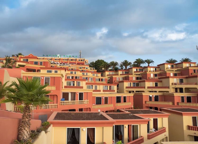 Laguna Park 2 in Playa de las Américas with terraced coral hotel buildings and palm trees