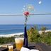 Casa Mermejita Mazunte terrace table with drinks and flowers, overlooking ocean and beach in Mazunte