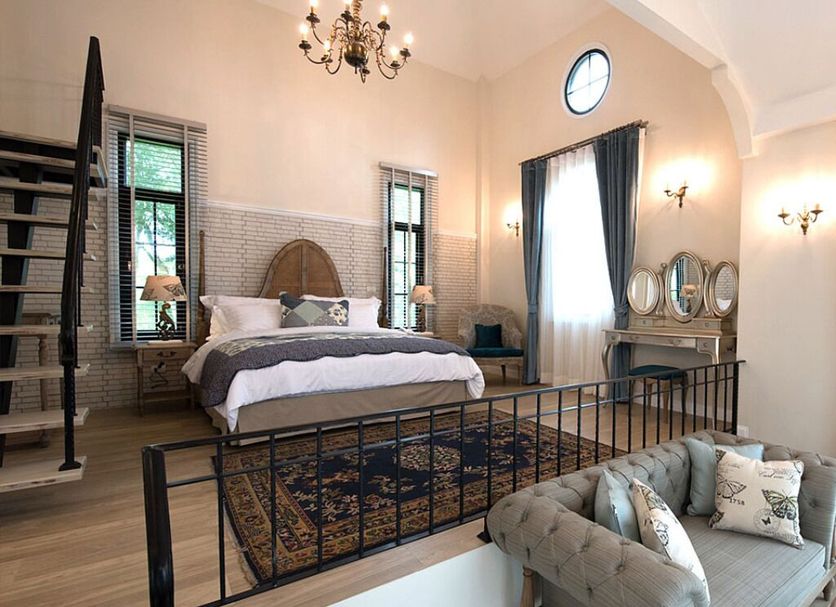 The Bluesky Resort @ Khao Kho bedroom with metal bed, chandelier, sofa and tall windows