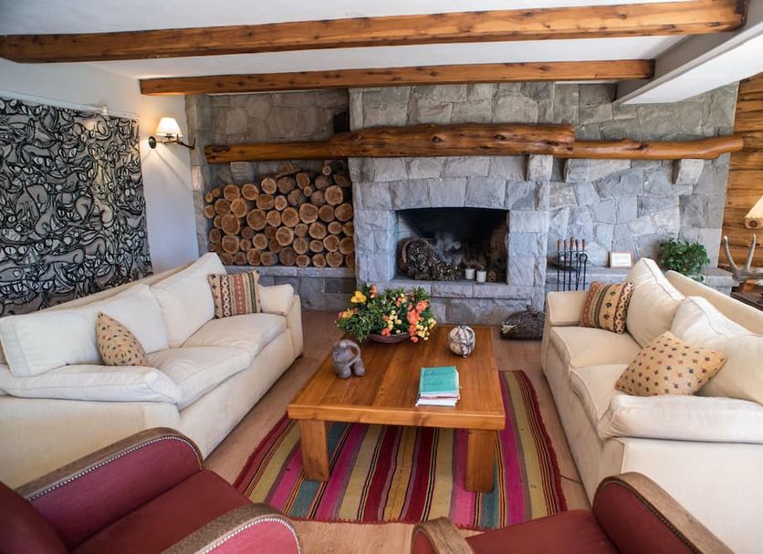 Las Marianas Hotel in San Carlos de Bariloche lounge with stone fireplace, sofas and wooden coffee table