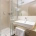 Kapuzinerhof in Biberach an der Riß bathroom with glass shower, wall-mounted sink and toilet