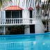 Mansion Giahn Bed & Breakfast in Cancún with poolfront balconies and red-roofed windows