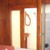 Wood House Pattaya in Pattaya: wooden room doorway opens to a small bathroom with toilet and shower