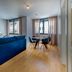 LSA Liberdade by Numa Lisbon living room with blue sofa, dining table, and large windows