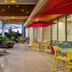 Home2 Suites by Hilton Idaho Falls patio with fire pit, red umbrellas, and mountain views